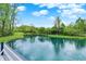 View of the pond at the end of the lush green backyard, with a deck area at 7425 E Thompson Rd, Indianapolis, IN 46239