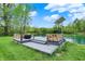 Scenic view of a pond with a deck, solar panel, and serene natural surroundings, creating a tranquil outdoor space at 7425 E Thompson Rd, Indianapolis, IN 46239