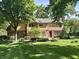 Back of home with brick and vinyl siding, a red door, and spacious yard at 7621 Forest Dr, Fishers, IN 46038