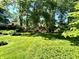 Lush, well-manicured backyard featuring mature trees, manicured lawns, and lovely landscaping at 7621 Forest Dr, Fishers, IN 46038