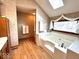 Bathroom with tub, skylight, and a patterned wallpaper design at 7621 Forest Dr, Fishers, IN 46038