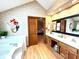 Bright bathroom offering a soaking tub, a mermaid wall art and vanity with double sinks and natural wood cabinets at 7621 Forest Dr, Fishers, IN 46038