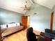 Bedroom featuring sloped ceilings, a futon couch and desk, with wooden floors and lots of natural light at 7621 Forest Dr, Fishers, IN 46038