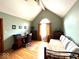 Bedroom with sloped ceilings, warm lighting, and a comfortable seating area with a desk and a futon couch at 7621 Forest Dr, Fishers, IN 46038