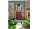 Up close view of brick exterior with red front door and manicured landscaping at 7621 Forest Dr, Fishers, IN 46038