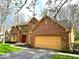 Attractive brick home featuring a two-car garage, well-kept lawn, and a beautiful red front door beneath an arched window at 7621 Forest Dr, Fishers, IN 46038