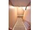 View of the carpeted basement stairway and wooden handrail at 7621 Forest Dr, Fishers, IN 46038