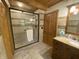 Tiled bathroom featuring a glass door shower, granite vanity, and wood door at 7916 N Lasalle Rd, Morgantown, IN 46160