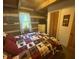 Cozy bedroom features log walls, a window, and a comfortable bed with a bear-themed comforter at 7916 N Lasalle Rd, Morgantown, IN 46160