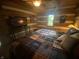 Inviting bedroom with log walls, TV, and natural light from the window at 7916 N Lasalle Rd, Morgantown, IN 46160