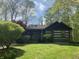 Quaint log cabin-style home with an American flag and a cozy porch surrounded by lush greenery at 7916 N Lasalle Rd, Morgantown, IN 46160
