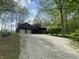 Charming log home featuring a two-car garage, gravel driveway, manicured front yard, and mature trees at 7916 N Lasalle Rd, Morgantown, IN 46160