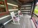 Charming log cabin porch with rocking chairs, a cozy spot to enjoy nature at 7916 N Lasalle Rd, Morgantown, IN 46160