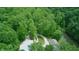 Aerial view of the house, barn, and driveway surrounded by trees and a small pond on the property at 8310 Goat Hollow Rd, Martinsville, IN 46151