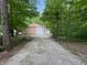 Long gravel driveway leading to a large storage building surrounded by a dense forest at 8310 Goat Hollow Rd, Martinsville, IN 46151