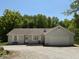 Charming one-story home featuring a two-car garage and a gravel driveway surrounded by lush trees at 8310 Goat Hollow Rd, Martinsville, IN 46151