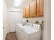 Functional laundry room with washer, dryer, and wooden cabinets for storage at 8310 Goat Hollow Rd, Martinsville, IN 46151