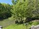 Lush green pond and backyard view with stone terracing at 8310 Goat Hollow Rd, Martinsville, IN 46151