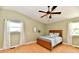 This bedroom features a ceiling fan, two windows with white curtains and a bed at 8548 Scarsdale W Dr, Indianapolis, IN 46256