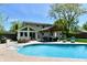 Backyard pool with a seating area, shade, a green lawn, and the home's rear exterior at 8548 Scarsdale W Dr, Indianapolis, IN 46256