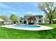 Inviting backyard pool with lounge chairs, an outdoor dining area, a covered patio, and a lush green lawn at 8548 Scarsdale W Dr, Indianapolis, IN 46256