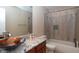 Bathroom featuring a modern vanity, granite countertop, decorative bowl sink and a shower-tub with patterned tile surround at 8814 W 30Th St, Indianapolis, IN 46234