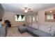 Relaxing living area with plush carpeting, a gray sectional, a ceiling fan, and view to front entry at 8814 W 30Th St, Indianapolis, IN 46234