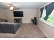 Comfortable living area with plush carpeting, a gray sofa, a ceiling fan, and a dedicated workstation at 8814 W 30Th St, Indianapolis, IN 46234