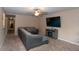 Spacious living room with plush carpeting, a gray sectional sofa, and a modern electric fireplace at 8814 W 30Th St, Indianapolis, IN 46234