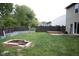 Spacious backyard with firepit, garden beds and basketball hoop surrounded by lush greenery at 8912 Hosta Way, Indianapolis, IN 46113