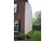 Exterior view showcasing brick and vinyl siding with green foliage and landscaping at 8912 Hosta Way, Indianapolis, IN 46113
