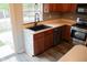 Well-lit kitchen with dark sink, stainless steel appliances and unique leaf-patterned cabinet trim at 8912 Hosta Way, Indianapolis, IN 46113