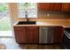 A modern kitchen featuring a black sink, stainless steel dishwasher, and sliding doors at 8912 Hosta Way, Indianapolis, IN 46113