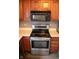 Kitchen with stainless steel stove, oven, and microwave, plus wood cabinets and light countertops at 8912 Hosta Way, Indianapolis, IN 46113