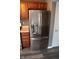 Modern stainless steel refrigerator with wood cabinets on either side at 8912 Hosta Way, Indianapolis, IN 46113