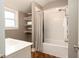 Bright bathroom featuring a tub with shower, built-in shelves, and wood-look vinyl flooring at 940 E Pleasant Run Parkway North Dr, Indianapolis, IN 46203