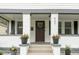 Charming front porch with a swing, potted plants, and a welcoming entrance, creating curb appeal at 940 E Pleasant Run Parkway North Dr, Indianapolis, IN 46203