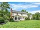 Expansive backyard featuring a well-manicured lawn, mature trees, and brick chimney at 9583 Greenthread Dr, Zionsville, IN 46077
