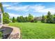 Spacious backyard showcasing a lush green lawn, landscaping, and brick walkway that adds to the property's charm at 9583 Greenthread Dr, Zionsville, IN 46077
