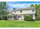 Well-maintained backyard with mature trees, green grass, brick patio, and enclosed sunroom, perfect for entertaining at 9583 Greenthread Dr, Zionsville, IN 46077
