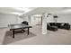 Well-lit basement with ping pong table, home theater setup, and comfortable seating area at 9583 Greenthread Dr, Zionsville, IN 46077