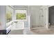 Bright bathroom featuring a soaking tub, a glass shower, and marble flooring at 9583 Greenthread Dr, Zionsville, IN 46077
