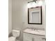 Well-lit powder room featuring a marble vanity and decorative mirror at 9583 Greenthread Dr, Zionsville, IN 46077