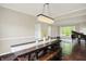 Bright dining room features hardwood floors, crown molding, and modern chandelier over a rustic table at 9583 Greenthread Dr, Zionsville, IN 46077