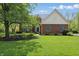 Charming brick home featuring a well-manicured lawn, mature tree, and traditional architectural details at 9583 Greenthread Dr, Zionsville, IN 46077