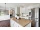 Open-concept kitchen with white cabinetry, stainless steel appliances, hardwood floors and granite countertops at 9583 Greenthread Dr, Zionsville, IN 46077