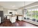 Sunlit kitchen offers white cabinetry, stainless appliances, breakfast nook and hardwood floors at 9583 Greenthread Dr, Zionsville, IN 46077