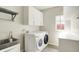 Modern laundry room featuring stainless steel sink and front loading washer and dryer at 9583 Greenthread Dr, Zionsville, IN 46077