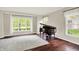 Bright living room with hardwood floors, large windows, and an antique piano; lots of natural light at 9583 Greenthread Dr, Zionsville, IN 46077