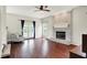 Cozy living room featuring a brick fireplace, hardwood floors, and natural light at 9583 Greenthread Dr, Zionsville, IN 46077